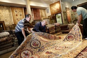 Alex Helmi, owner of Damoka, a newly set up shop in Los Angeles, receives his first shipment of rugs from Iran. Image credit: LA Times